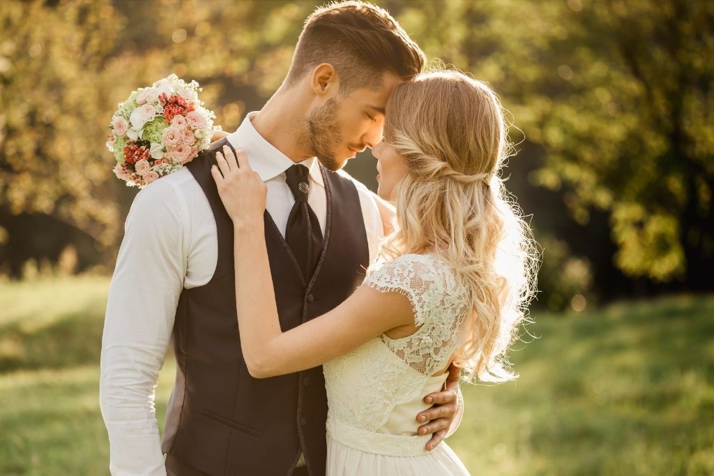 Wesele w plenerze – najpiękniejsze zakątki Śląska na romantyczną uroczystość ślubną 2 Nowożeńcy w romantycznym uścisku podczas sesji zdjęciowej w plenerze, otoczeni zielenią i miękkim światłem zachodzącego słońca. Naturalna sesja ślubna podkreślająca urok wesela na świeżym powietrzu.